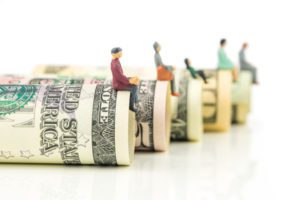 retirement account rollover people sitting on rolled dollar bills money