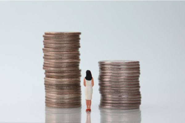 woman considering two stacks of coins financial tips after promotion