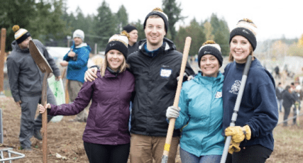 Four Brighton Jones employees holding shovels at a Compassion in Action event