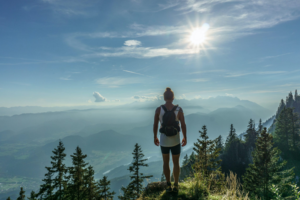 Woman hikes mountain to scenic viewpoint