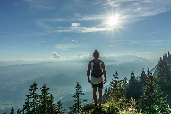 Woman hikes mountain to scenic viewpoint