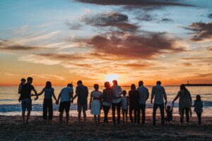 Extended family on a beach at sunset