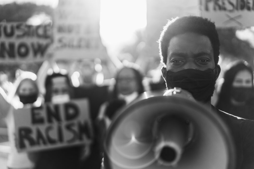 People from different culture and races protest on the street for equal rights - Focus on black man eyes