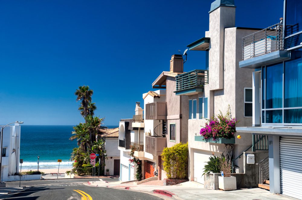 Modern homes lining a street near Manhattan Beach California on a sunny blue sky day.